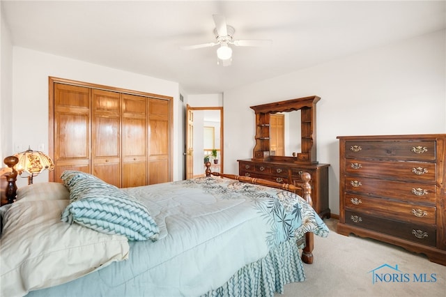 carpeted bedroom featuring ceiling fan and a closet