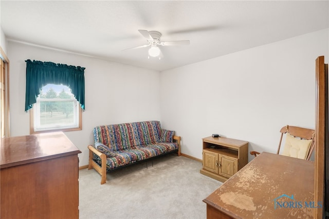 living area with light colored carpet and ceiling fan