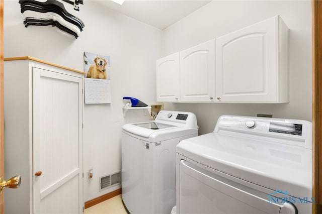 washroom with cabinets and washing machine and dryer