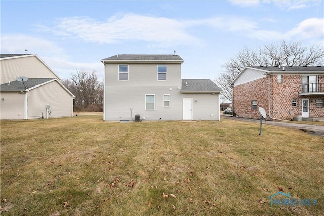 back of house featuring a yard and central AC