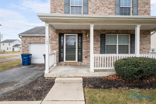 doorway to property featuring a garage and a porch