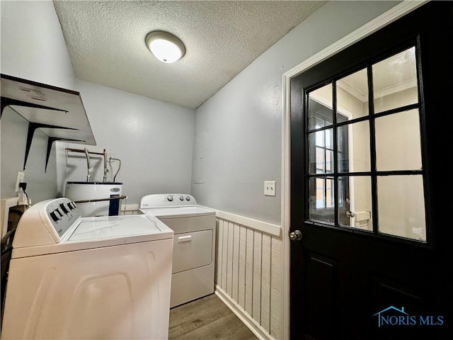 laundry room with light hardwood / wood-style flooring, washer and clothes dryer, water heater, and a textured ceiling