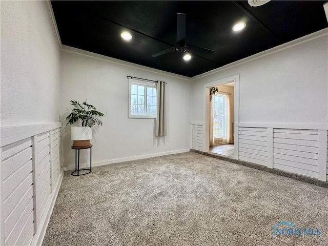 empty room with ornamental molding, light colored carpet, and ceiling fan