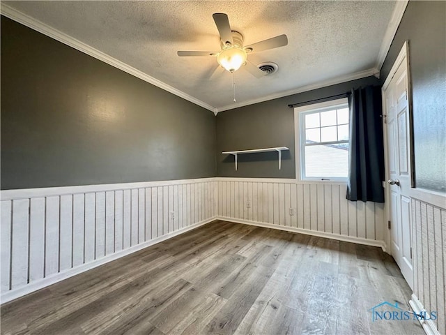 unfurnished room featuring ceiling fan, ornamental molding, wood-type flooring, and a textured ceiling