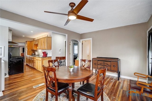 dining space featuring a textured ceiling, hardwood / wood-style floors, and ceiling fan