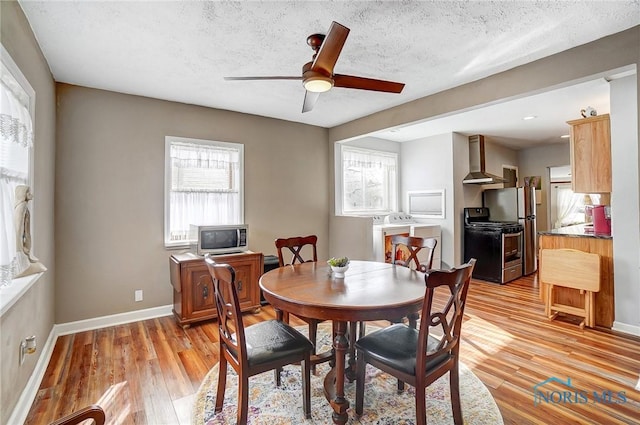 dining room with ceiling fan, light wood-type flooring, a textured ceiling, and washer / clothes dryer