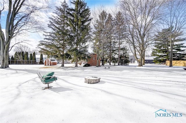 snowy yard featuring a fire pit