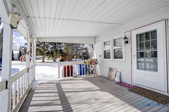 snow covered deck with covered porch