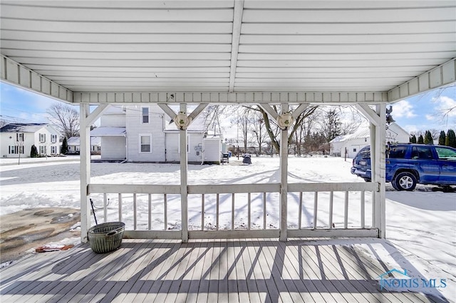 snow covered deck with a carport