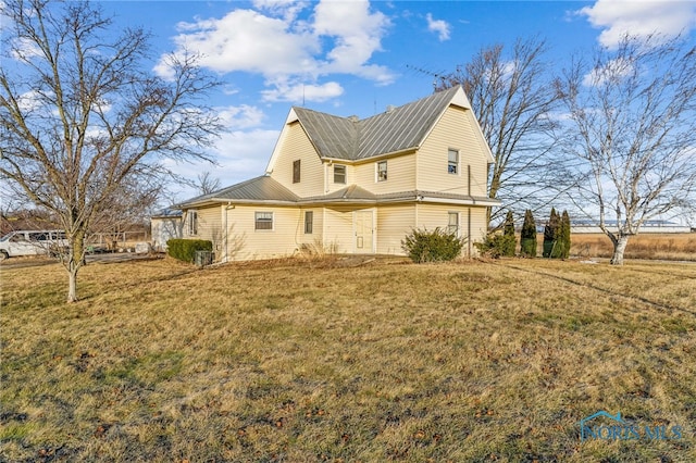 rear view of property with a yard