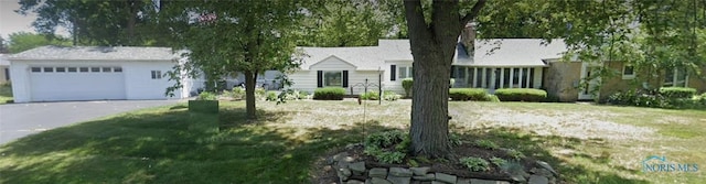 ranch-style house featuring a front lawn and a garage