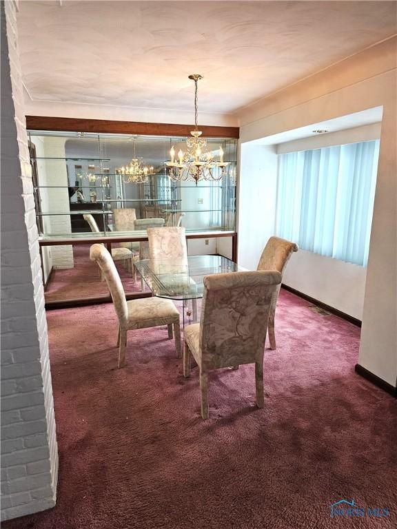 dining area with carpet floors and an inviting chandelier