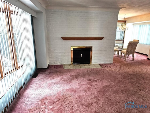 living room with a chandelier, carpet floors, and a fireplace