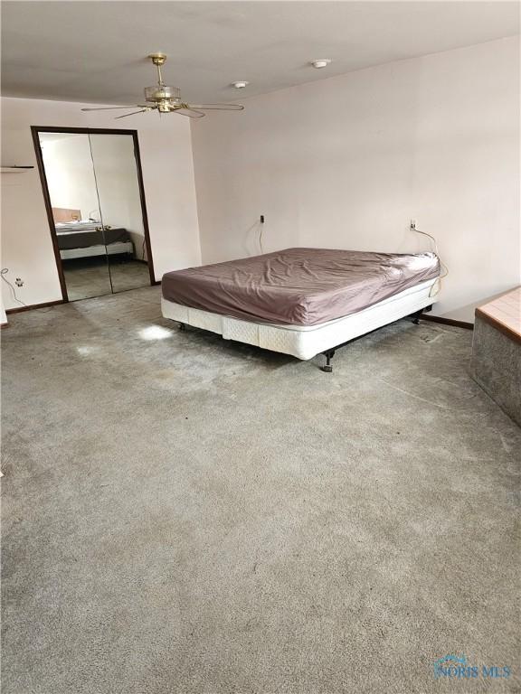 unfurnished bedroom featuring carpet floors, a closet, and ceiling fan