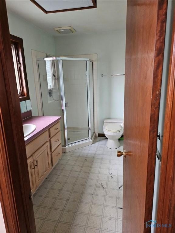 bathroom featuring vanity, an enclosed shower, and toilet