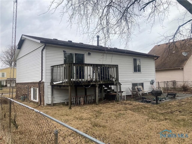 back of house with a wooden deck and a yard