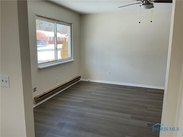 empty room with a ceiling fan, baseboards, a baseboard heating unit, and dark wood-type flooring