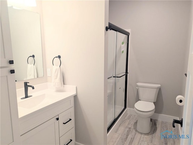 bathroom with vanity, wood-type flooring, toilet, and walk in shower