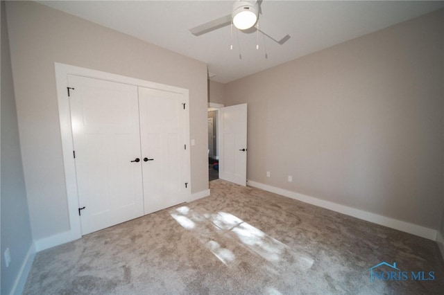 unfurnished bedroom featuring ceiling fan, a closet, and carpet