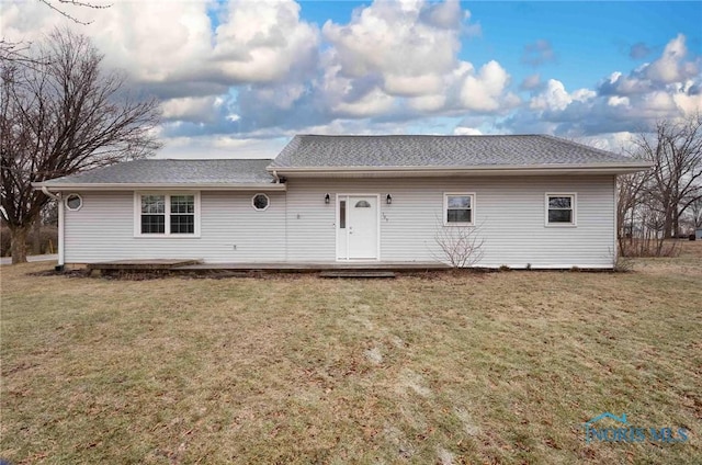 rear view of property featuring a lawn