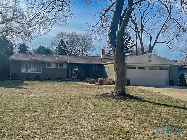 ranch-style house with a garage and a front lawn