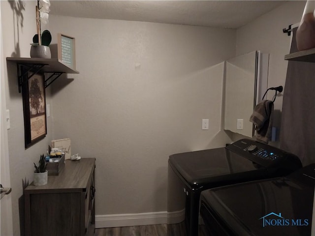 clothes washing area with hardwood / wood-style floors and washer and clothes dryer