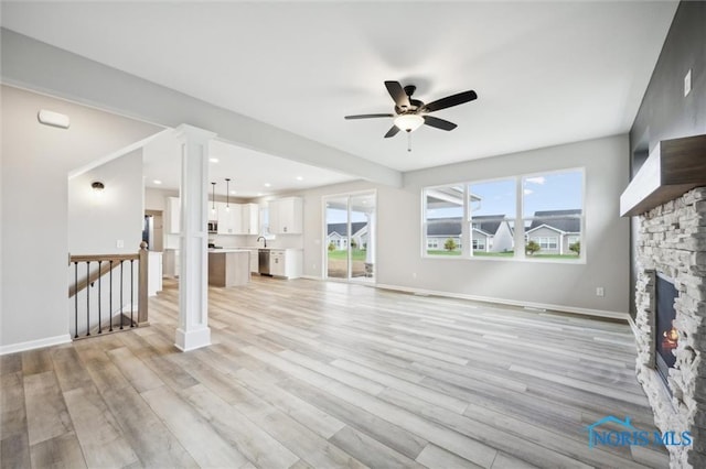 unfurnished living room with a fireplace, light hardwood / wood-style floors, and ceiling fan