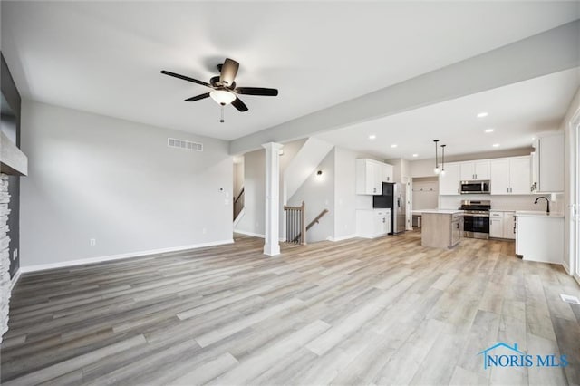 unfurnished living room with ceiling fan, sink, and light hardwood / wood-style floors