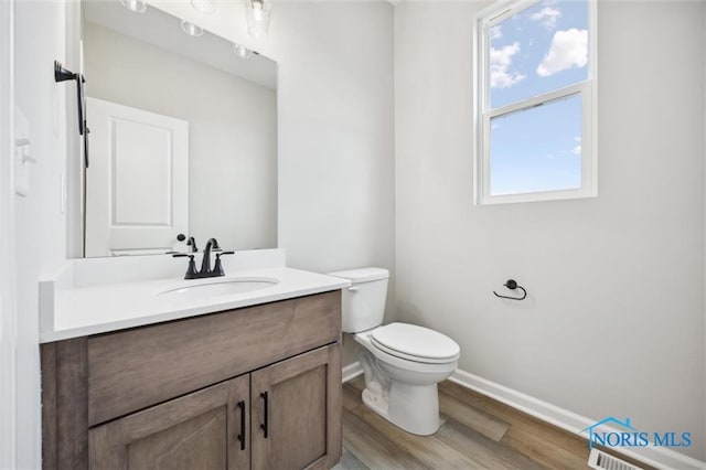 bathroom featuring hardwood / wood-style flooring, vanity, and toilet