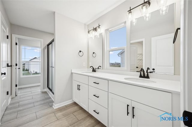 bathroom with vanity and a shower with door