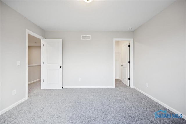 unfurnished bedroom with carpet floors and a walk in closet