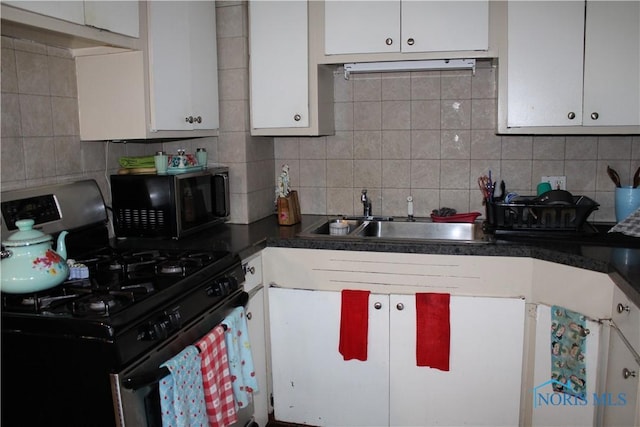 kitchen with white cabinets, sink, decorative backsplash, and stainless steel gas range oven