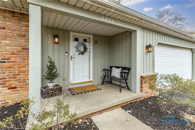 doorway to property with a garage and covered porch