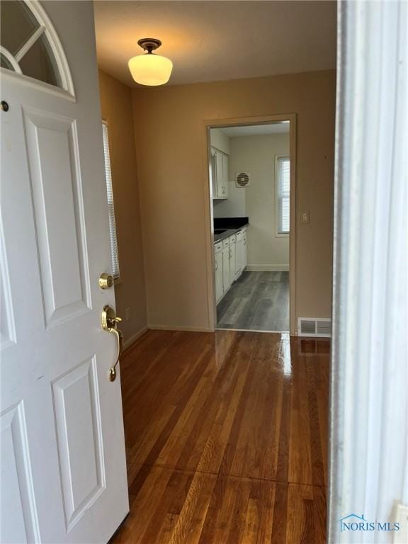 corridor with dark hardwood / wood-style flooring