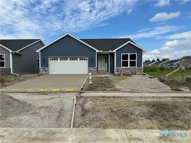 2016 Oakside, Toledo, OH 43615 - view of front of home featuring stone siding, an attached garage, and driveway