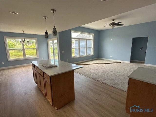 2016 Oakside, Toledo, OH 43615 - kitchen featuring baseboards, brown cabinetry, a ceiling fan, light wood finished floors, and light stone countertops