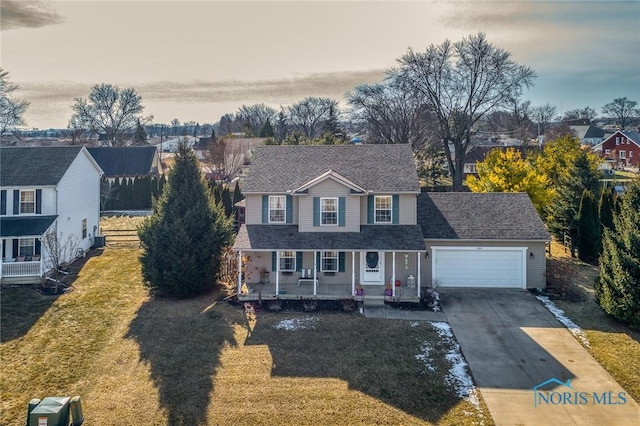 view of front of house featuring a porch, a garage, and a front yard