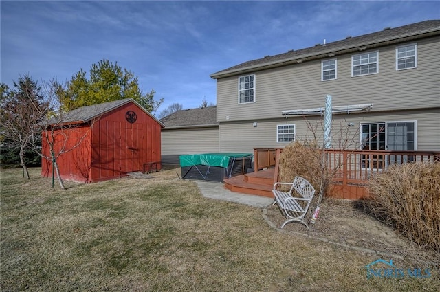 back of house featuring a storage shed, a yard, and a deck