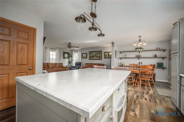 kitchen with gray cabinetry, decorative light fixtures, dark hardwood / wood-style flooring, and a kitchen island