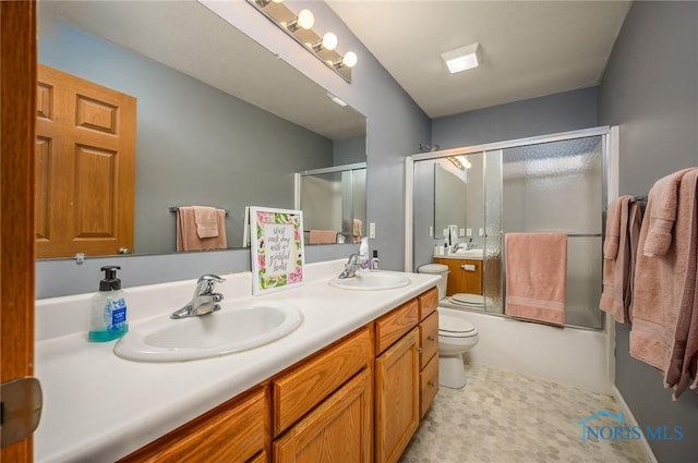 full bathroom featuring toilet, vanity, and shower / bath combination with glass door