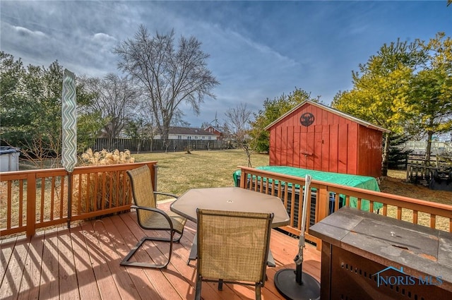 wooden deck featuring a storage shed and a lawn