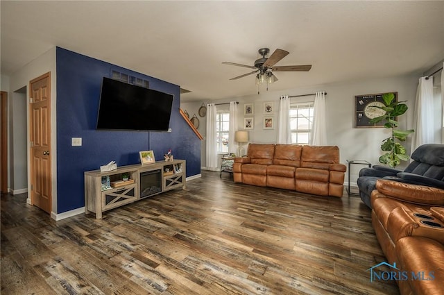 living room with dark wood-type flooring and ceiling fan