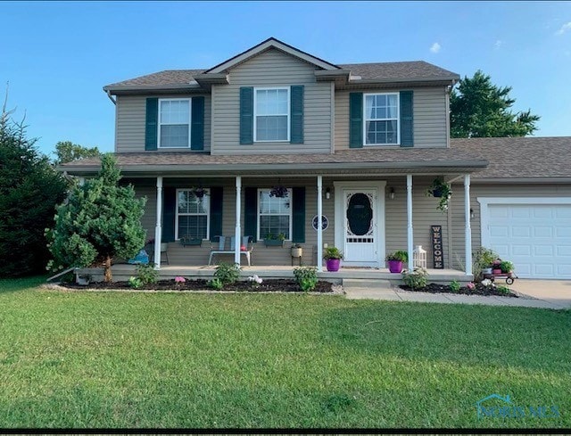 view of front of home featuring a garage, a front lawn, and covered porch