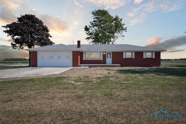 ranch-style house with a garage and a yard