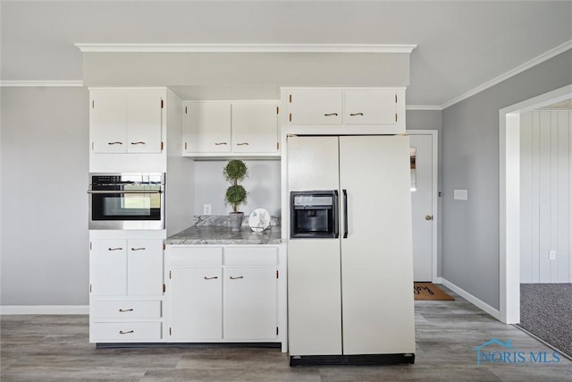 kitchen featuring light hardwood / wood-style flooring, ornamental molding, white fridge with ice dispenser, white cabinets, and stainless steel oven