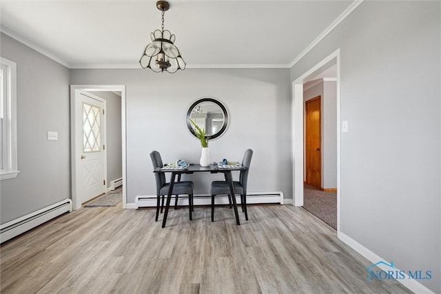 dining area with a baseboard heating unit, crown molding, light hardwood / wood-style floors, and a chandelier