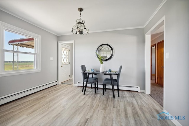 dining area with an inviting chandelier, crown molding, a baseboard radiator, and light hardwood / wood-style floors