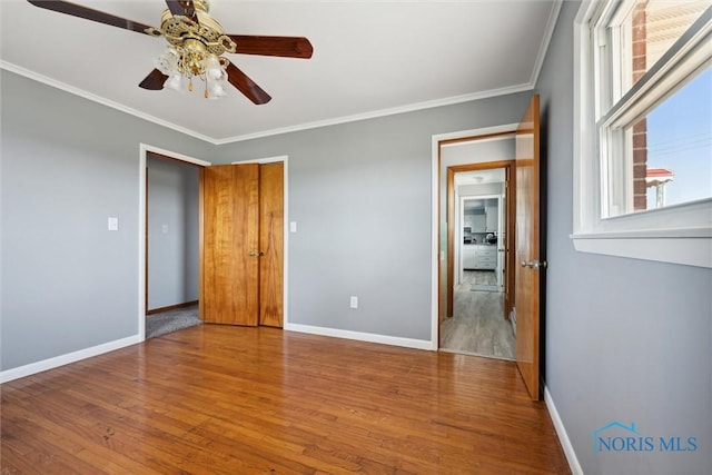 unfurnished bedroom featuring ceiling fan, ornamental molding, and wood-type flooring