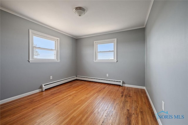 empty room with a baseboard radiator, ornamental molding, light wood-type flooring, and a wealth of natural light