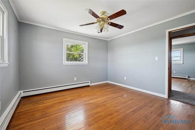 spare room featuring wood-type flooring, ornamental molding, and baseboard heating